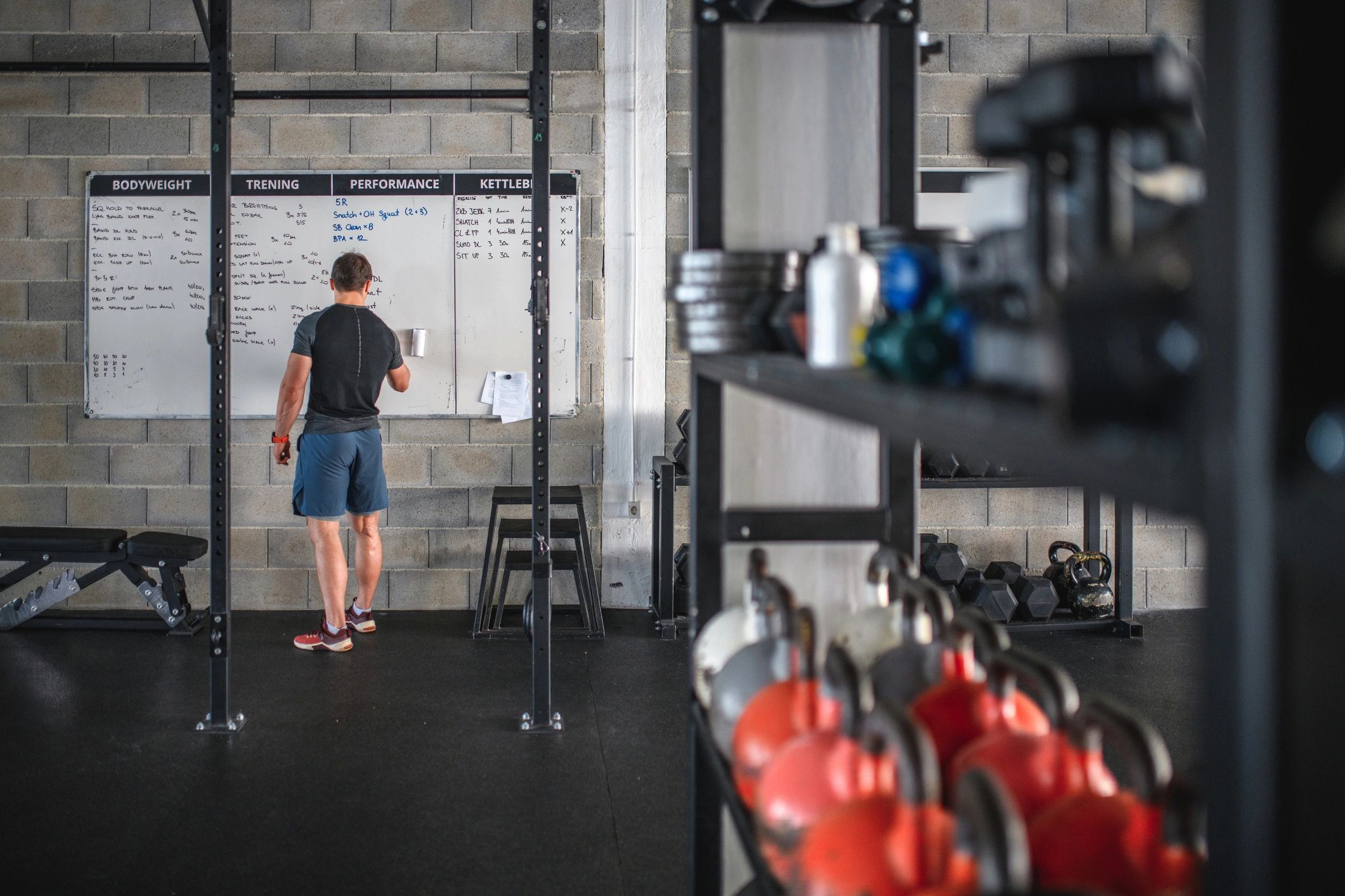 Coach writing a workout plan on a whiteboard in a training facility