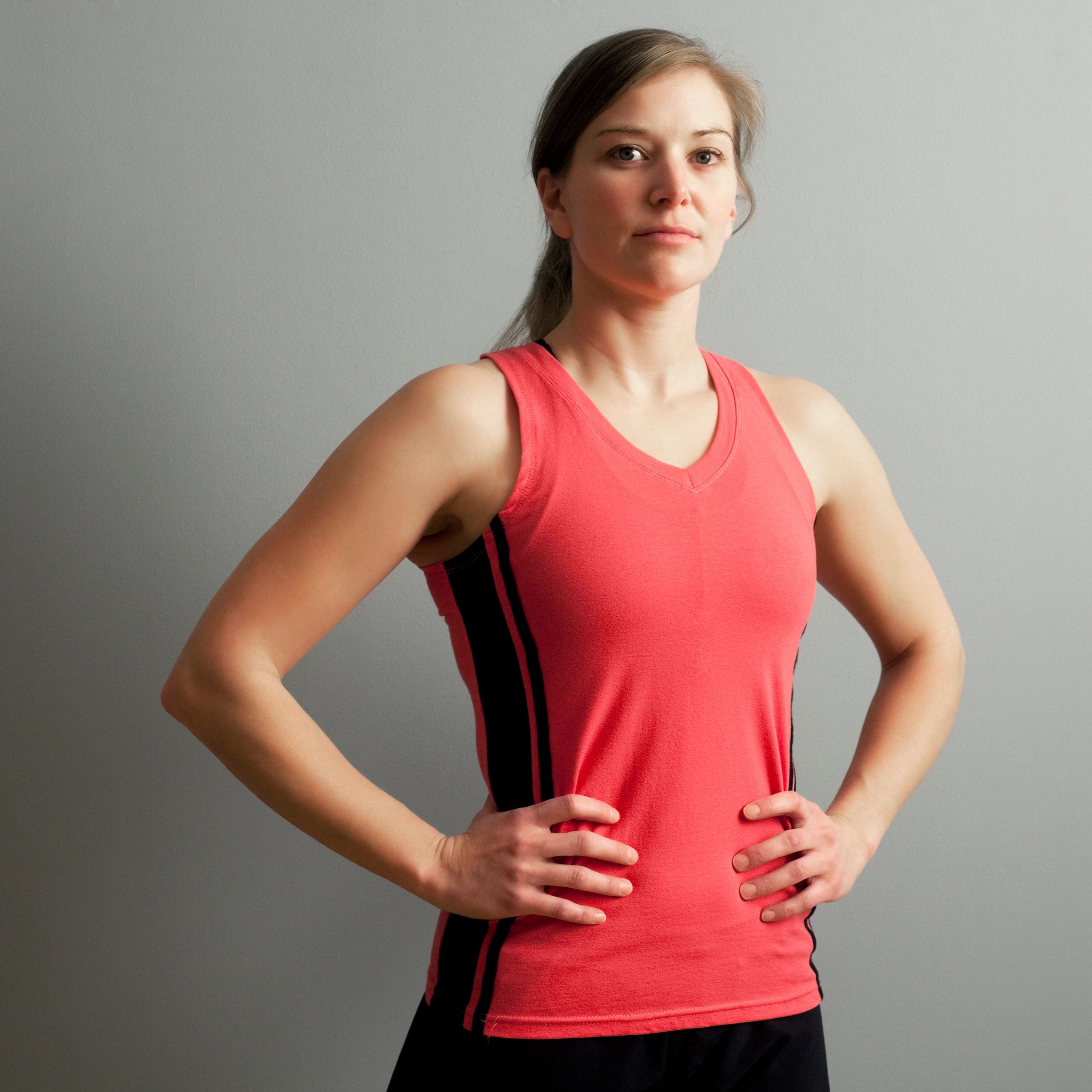 Portrait of a fit woman in sportswear with hands on hips