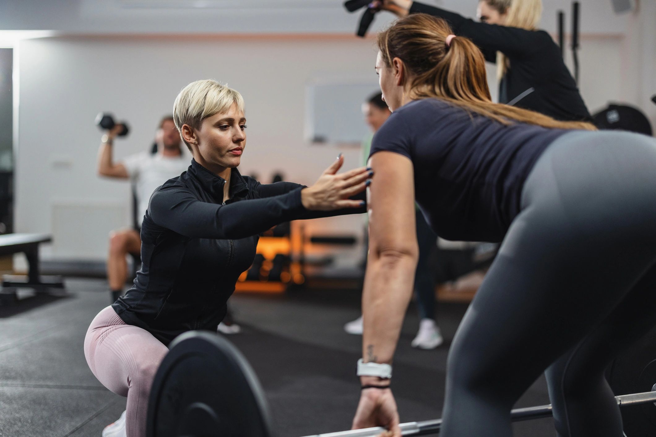 Trainer coaching a client during a deadlift for strength training