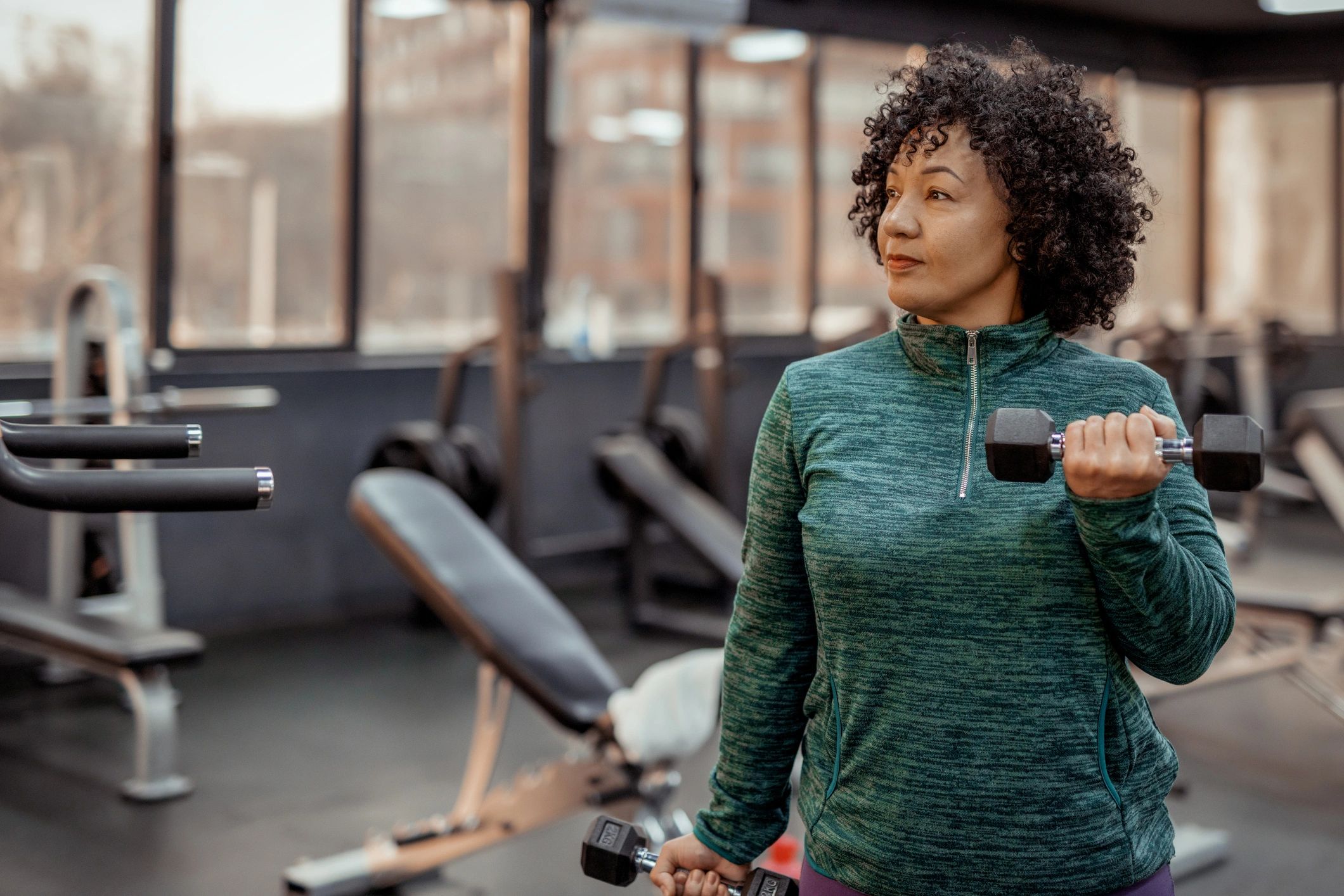 Determined woman performing dumbbell strength training