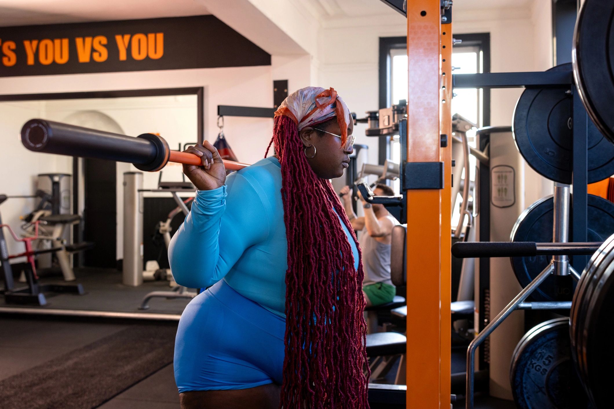 Woman strength training with a barbell in a gym