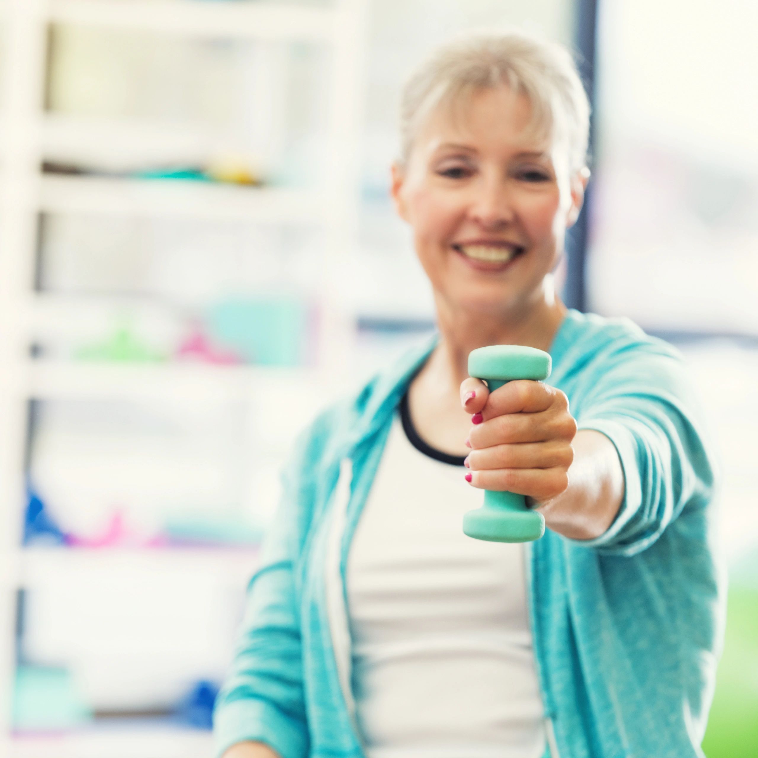 Gym client holding a dumbbell toward the camera