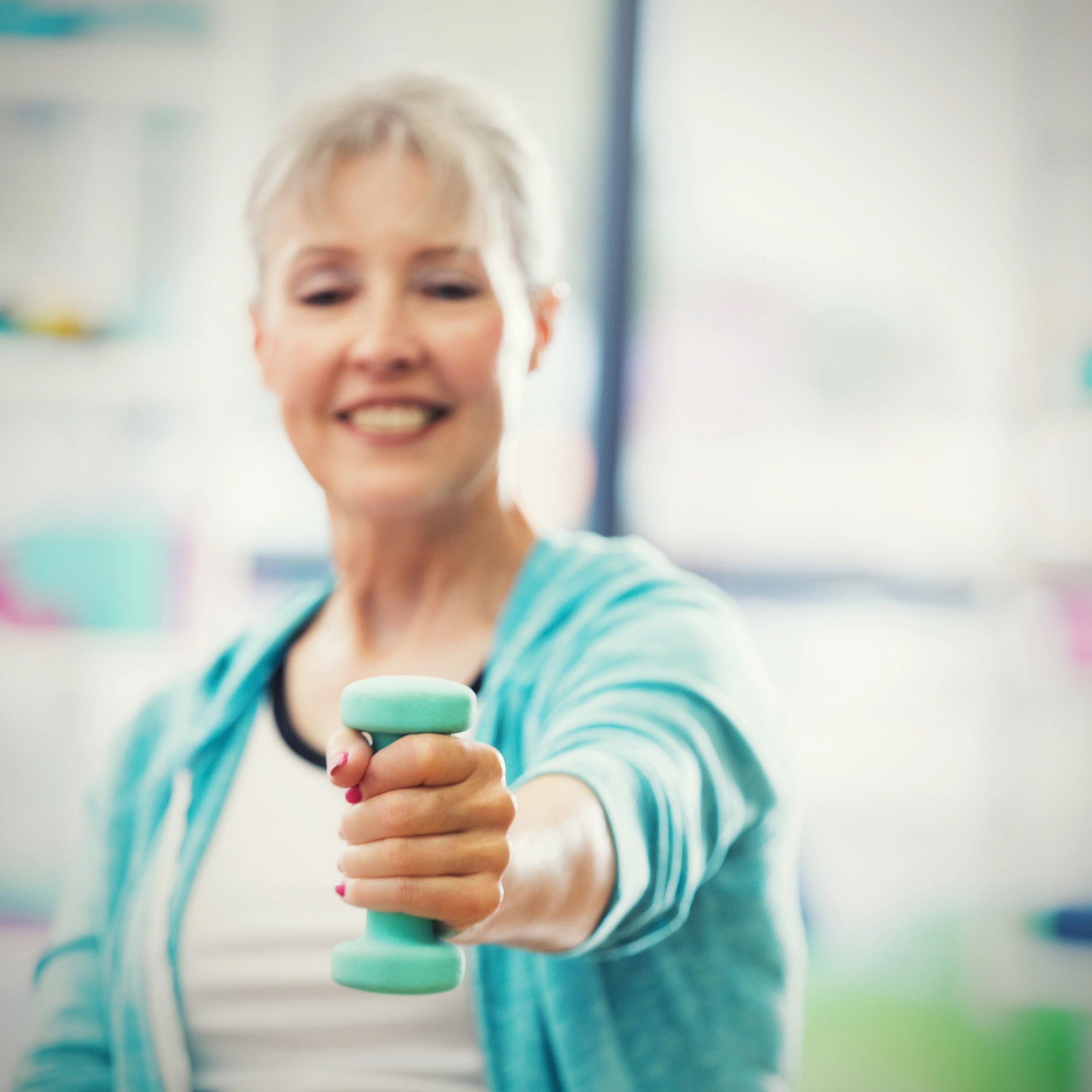 Smiling gym client holding a weight